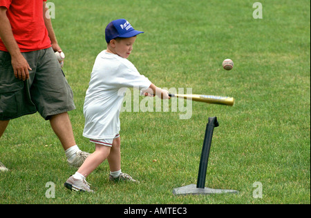 4 and 5 year old boys and girls learn how to hit a ball off of a tee Stock Photo