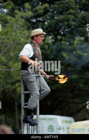 Fire eater on a ladder street performance Stock Photo