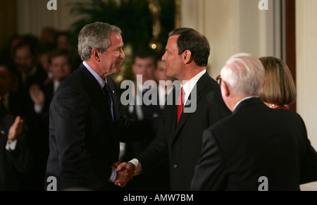Chief Justice of the United States John Roberts shakes hands with President George W Bush in the East Room of the White House Stock Photo