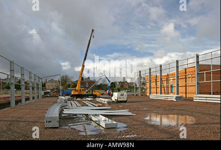 Crane lifting steel beams on construction site Stock Photo