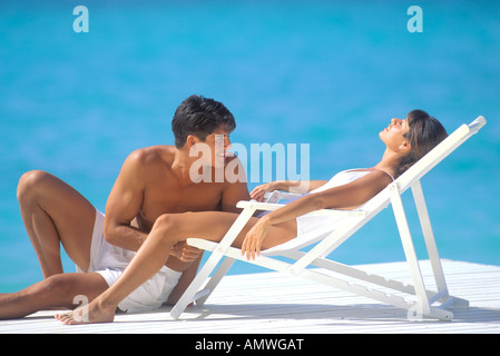 USA, Hawaiian Islands. Couple relaxing on oceanside dock Stock Photo