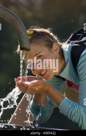 young woman drinking pure water from mountains, France, Alps Stock Photo