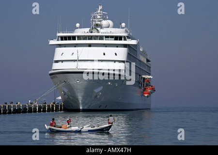fishing boat in front of cruise liner Seven Seas Navigator, Turkey, Kusadasi Stock Photo