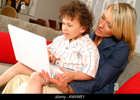 Mid adult woman and her son using laptop Stock Photo