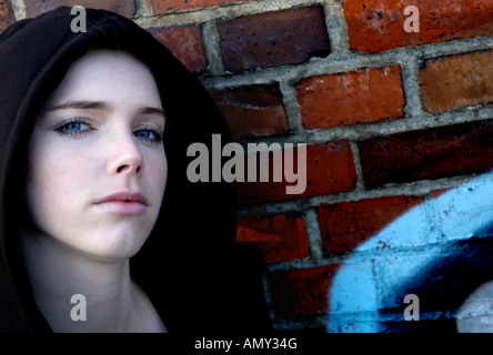 Portrait of young woman leaning against wall Stock Photo