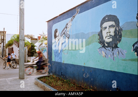 Mural on a street corner in Holguín Cuba depicting Che Guevara and a man pointing a rifle Stock Photo
