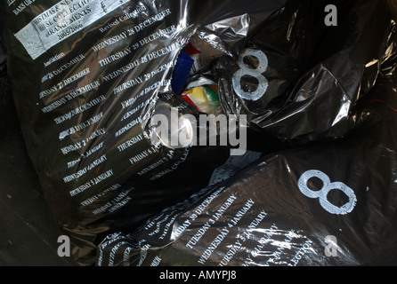Rubbish bag with rip in its side and refuse visible inside waiting for collection. Stock Photo