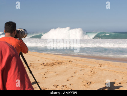 Photographer photographing surfer on a classic big barreling surfing wave at the Banzai Pipeline North Shore of Oahu Hawaii Stock Photo