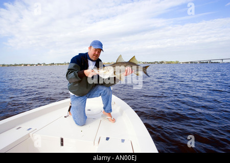 Man with freshly caught snook fish in Stuart, Florida, USA Stock Photo