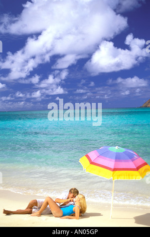 USA, Hawaiian Islands. Couple relaxing on tropical beach Stock Photo