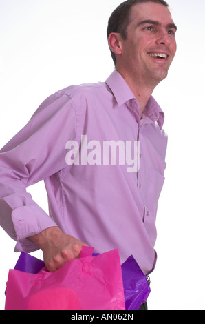 Young man holding bright shopping bags smiling after a shopping trip Stock Photo