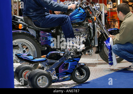 Big boys toys large and small trike with admiring adults Stock Photo