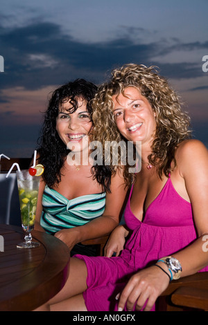Maldives South Male Atoll Olhuveli Resort two young women enjoying sunset cocktails Stock Photo
