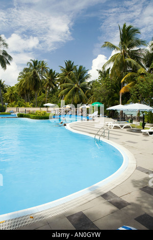 Maldives Addu Atoll Gan Equator Village Resort guests relaxing by the swimming pool Stock Photo