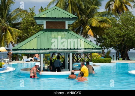 Maldives Addu Atoll Gan Equator Village Resort guests relaxing by the swimming pool bar Stock Photo