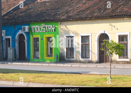 On the boulevard Ivana Cronjevica. Shops in small colourful houses. One shop with a sign saying 'New Industry'. Podgorica capital. Montenegro, Balkan, Europe. Stock Photo