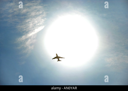 commercial jet aircraft flying in front of the sun. Stock Photo