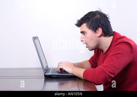Shocked man typing on laptop computer keyboard Stock Photo