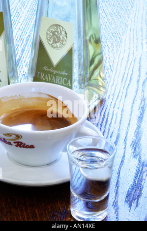 Triangular pyramid shaped Bottles of Travarica rakija grappa type grape spirit, a cup of espresso coffee and a glass of digestif alcohol. In the restaurant and wine bar at the winery. Podrum Vinoteka Sivric winery, Citluk, near Mostar. Federation Bosne i Hercegovine. Bosnia Herzegovina, Europe. Stock Photo