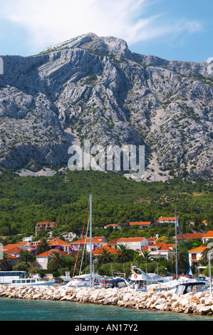 A view over the village and the massive mountains on the peninsula with undulating pattern. the pleasure boat harbour. Mount Sveti Ilija mountain. Orebic town, holiday resort on the south coast of the Peljesac peninsula. Orebic town. Peljesac peninsula. Dalmatian Coast, Croatia, Europe. Stock Photo