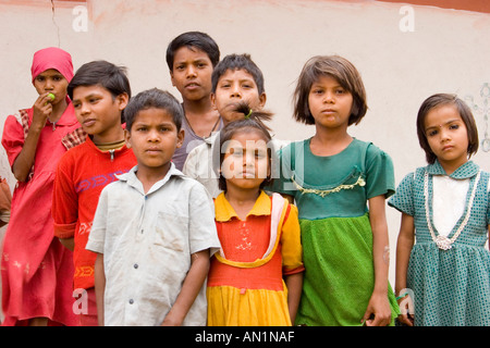 Indian children, standing side by side in front of a wall, India, Madhya Pradesh, Tala/Bandhavgarh NP, Mai 05. Stock Photo