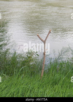 wooden stick fishing rod stand by river Stock Photo - Alamy