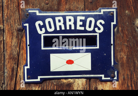 Blue enamel letterbox with the word Correos - post - printed on it along with a picture of an envelope.Spain Stock Photo