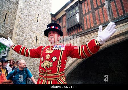 England, London, Tower of London, Beefeater in State Dress giving Guided Tour to Tourists Stock Photo
