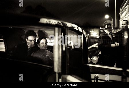 Timeless black and white image, a wedding couple sits in the back of an old-fashioned car. Stock Photo