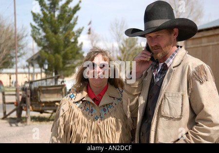 Caucasian couple visiting historic Tombstone, Arizona, as man talks on cellphone during sightseeing, USA. Stock Photo