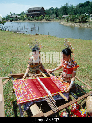 Iban Women Dressed in Traditional Costume doing Traditional Weaving, Sarawak, Malaysia Stock Photo