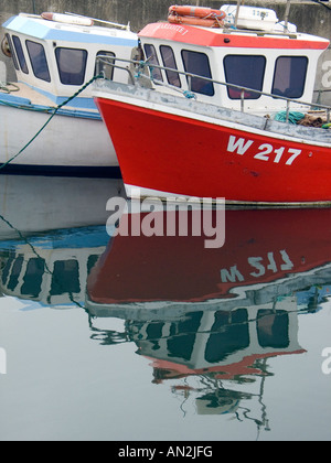 Two fishing boats moored in the harbour of Union Hall West Cork Ireland with reflections in the water Stock Photo