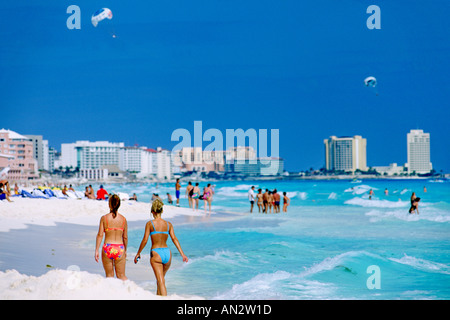 Two bikini-clad women walking on the Cancun beach on Mexico's Caribbean coast. Stock Photo