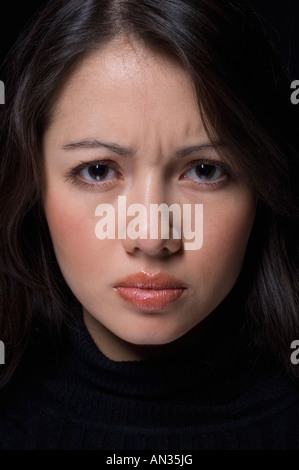 Close up of Hispanic woman furrowing brow Stock Photo