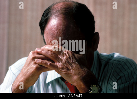 Stressed caucasian male executive holding head in hands worrying Stock Photo