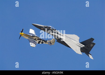 A world war two P51 Mustang and modern F15 eagle flying in formation at an air show. Stock Photo