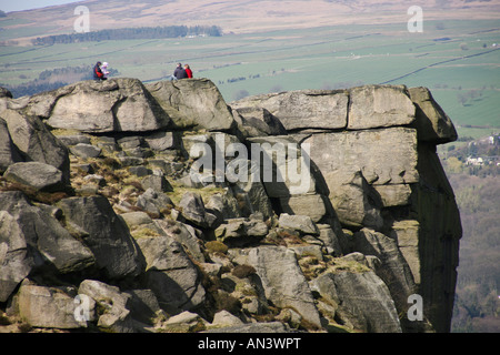 Visitors on top of the Cow and Calf Rocks Ilkley Yorkshire England The outcrops are on the edge of the renowned Ilkley Moor Stock Photo
