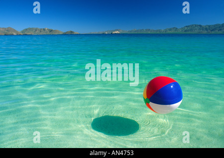 Beach ball floating in tropical water Stock Photo