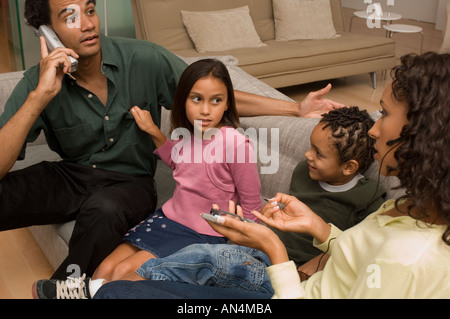 Portrait of two parents trying to ignore their children while on the phone Stock Photo