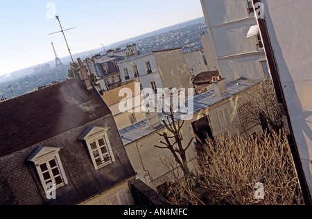 The distant Eiffel Tower seen over the rooftops in Paris Stock Photo