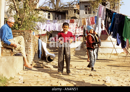 Children hanging up laundry in village, Kathmandu, Nepal Stock Photo