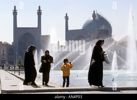 Female devotees walking past water fountain at mosque, Esfehan, Iran Stock Photo