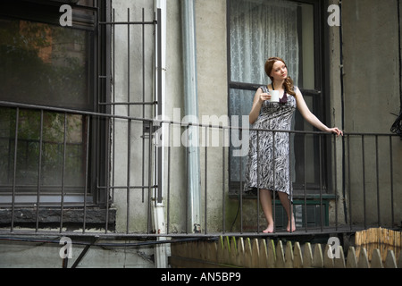 Woman drinking morning coffee on balcony Stock Photo