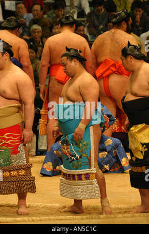 Sumo wrestlers in colourful silk robe costumes complete a pre fight ritual ceremony at the Osaka Spring Sumo Tournament, Japan Stock Photo