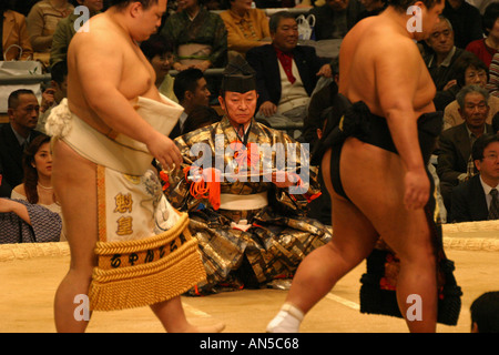 Sumo wrestlers enter the clay ring for the pre fight ceremony at the Spring sumo tournament in Osaka Japan Asia Stock Photo