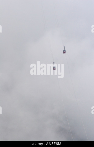 Cable cars of the Aiguille du Midi emerging from the clouds Stock Photo