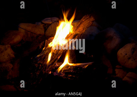 Campfire at night with stones around the edge of fire pit Stock Photo