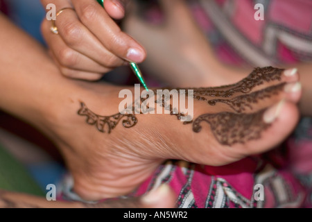 Art of Mehendi on feet. Painting henna to stain and colour skin in traditional artistic patterns. Stock Photo