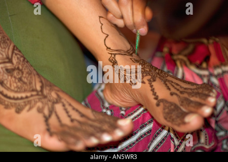 Art of Mehendi on feet. Painting henna to stain and colour skin in traditional artistic patterns. Stock Photo