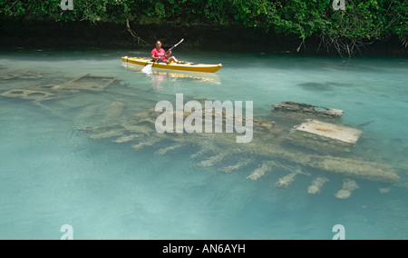 Kayker inspects sunken Japanese patrol boat in Shipwreck Bay Stock Photo